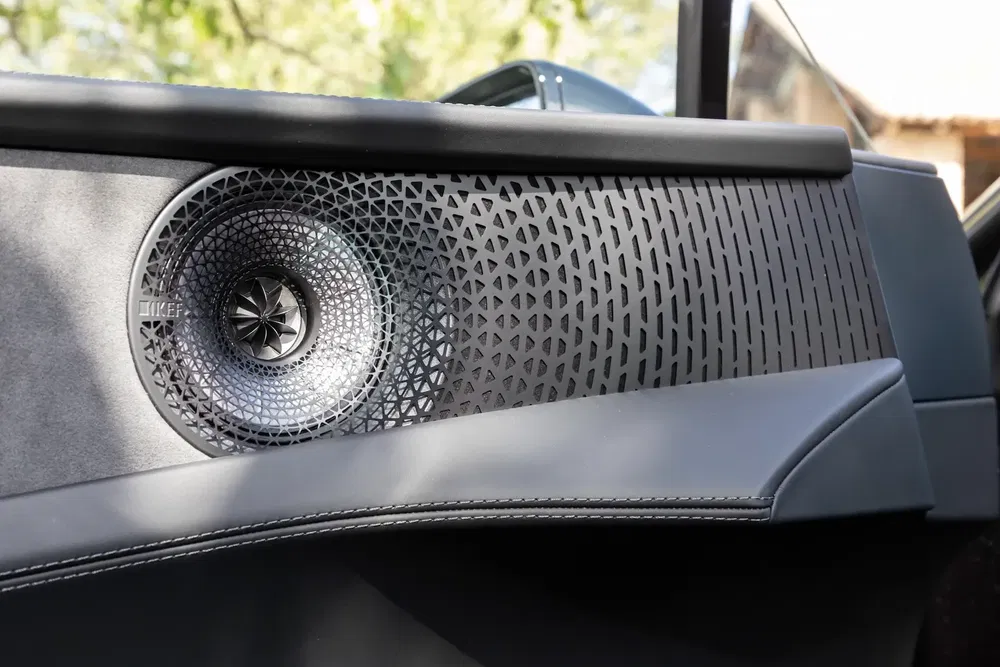Haut-parleur design intégré dans l'intérieur de porte de voiture moderne, motif géométrique élégant.