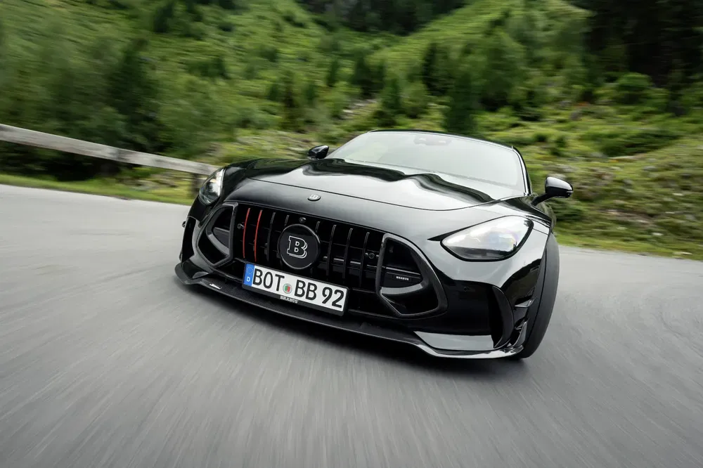 Voiture Brabus noire élégante sur route sinueuse en montagne.