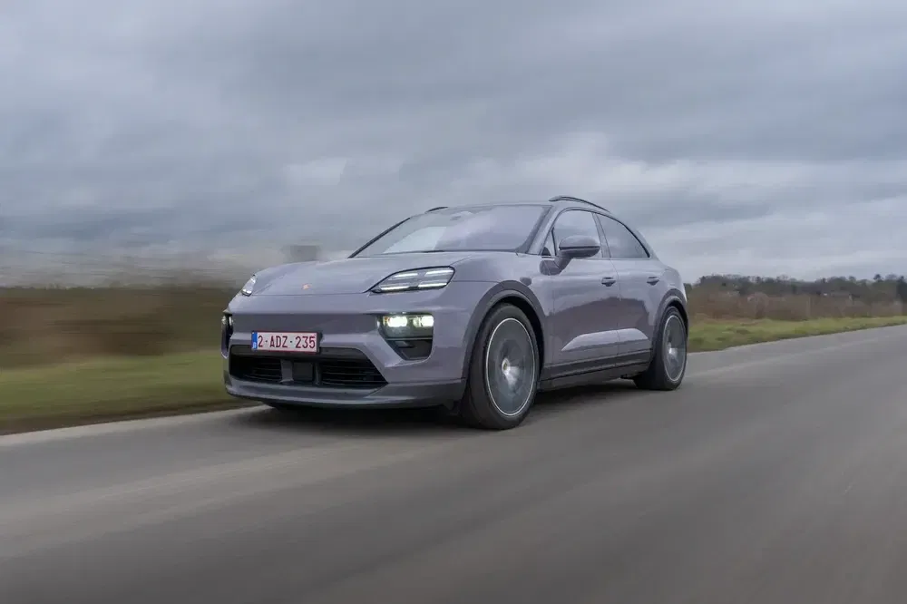 {"fr":"Voiture électrique Porsche Macan roulant sur une route de campagne sous un ciel nuageux.","nl":"Elektrische Porsche Macan rijdt op een plattelandsweg onder een bewolkte hemel."}