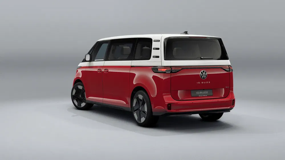 Volkswagen ID.Buzz rood-wit geparkeerd, stijlvolle achterzijaanzicht op grijze achtergrond.