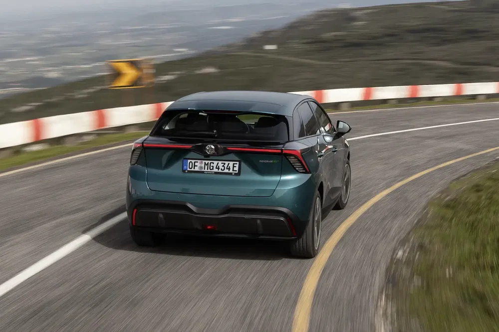 MG4 elektrische auto op kronkelige bergweg, focus op dynamisch rijgedrag.