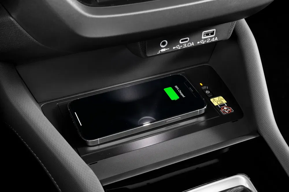 Draadloze smartphone-oplader in het interieur van een moderne auto, USB-C zichtbaar.