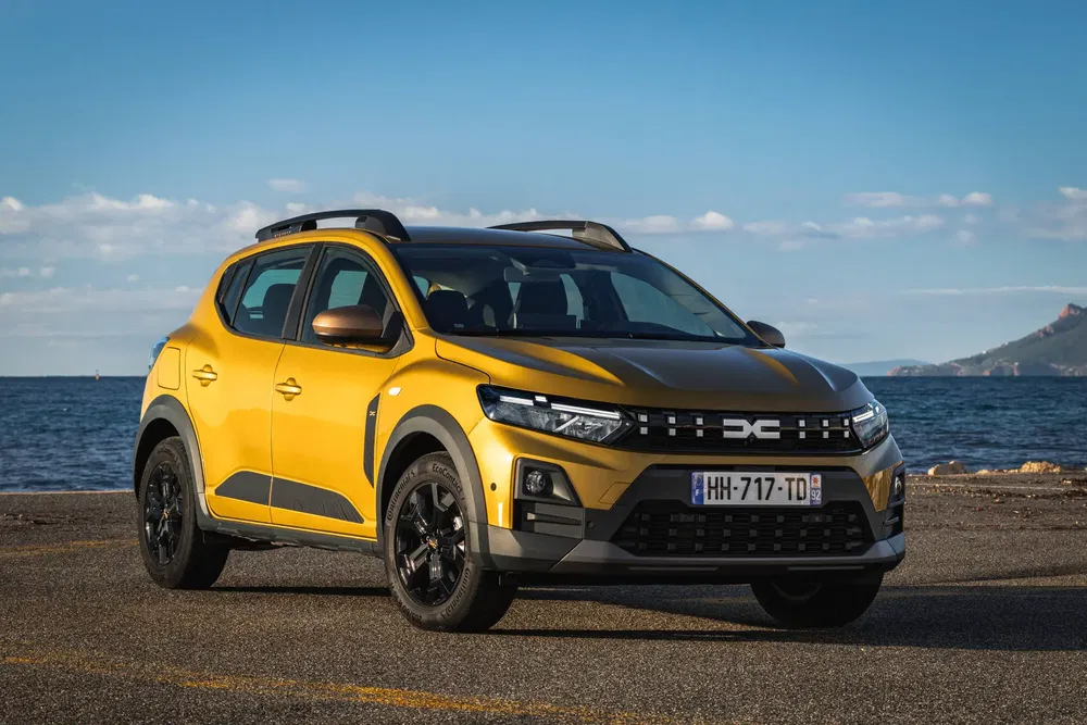Gele Dacia Sandero Stepway aan zee, modern en robuust ontwerp.