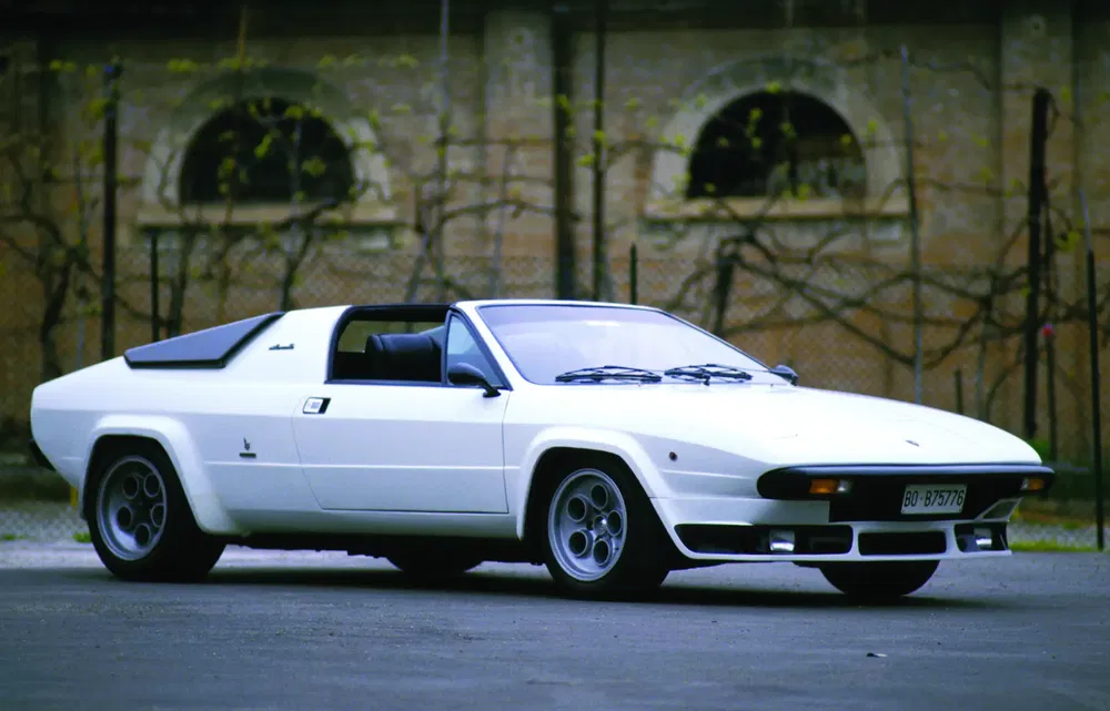 Lamborghini Jalpa blanche des années 1980 garée devant un bâtiment historique.