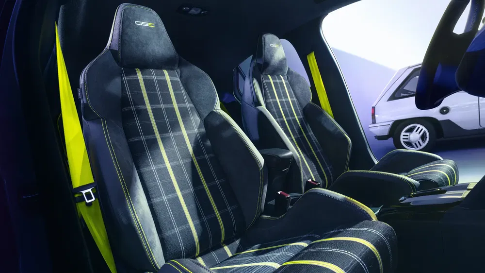 Intérieur sport de voiture avec sièges en tissu à motif à carreaux et surpiqûres jaunes.