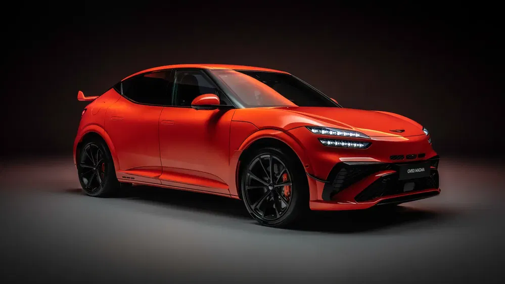 Genesis GV60 électrique rouge élégant illumine une scène sombre.