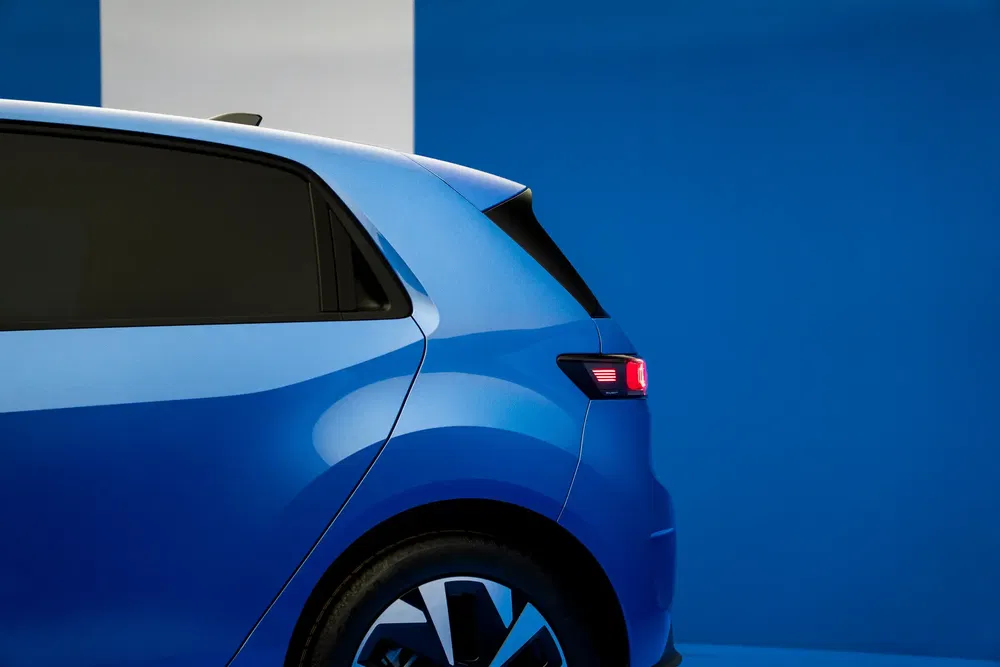 Vue arrière d'une voiture électrique Volkswagen ID.3 bleue sur fond bleu vif.