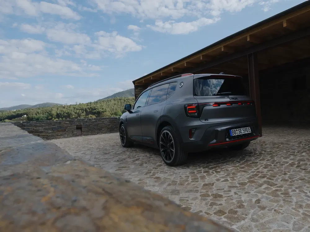 Moderne SUV op geplaveide oprit met kenmerkende achterkant en natuurlijke landschappen.