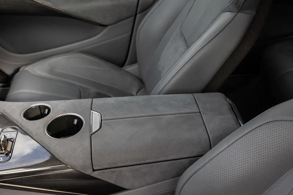 Intérieur de voiture avec console centrale en alcantara et porte-gobelets, design moderne et élégant.