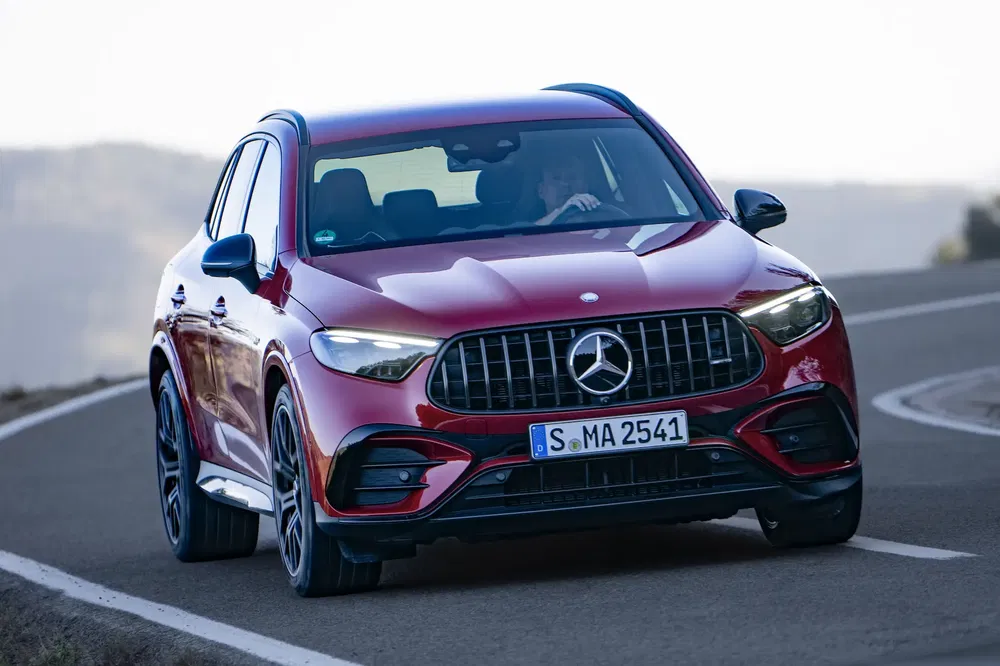 Rode Mercedes-Benz GLC op kronkelige weg, sportieve prestaties, modern design.