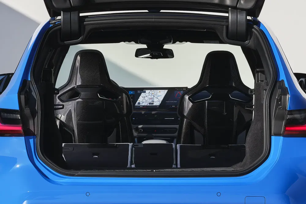 Ruime binnenkant van een BMW iX1 met moderne stoelen en dashboard, gezien vanuit de kofferbak.