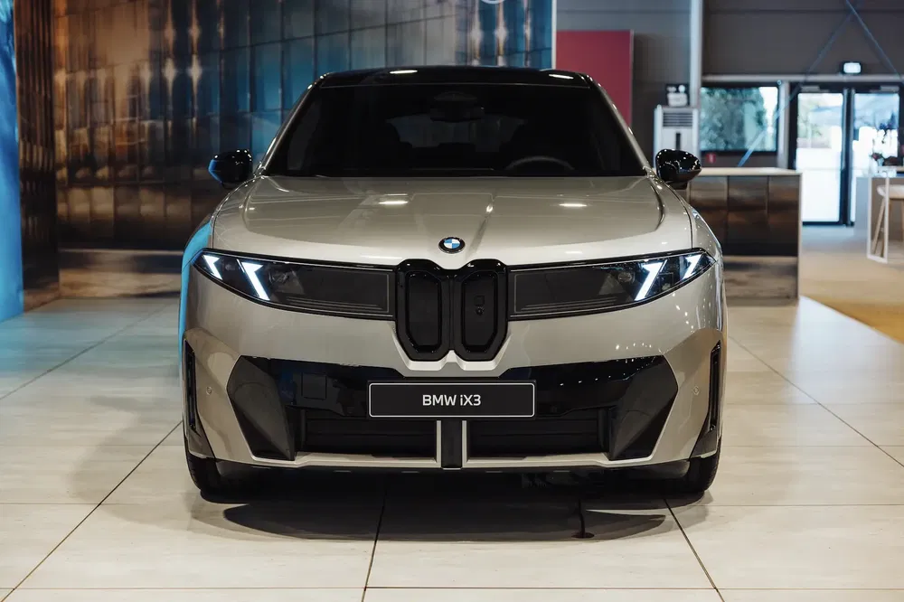 Elektrische BMW iX3 in moderne showroom, met een imposant frontaal ontwerp.