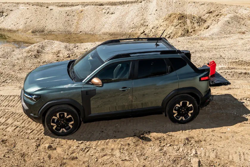 SUV compact sur terrain sablonneux, design moderne avec porte-bagages et accents en cuivre.