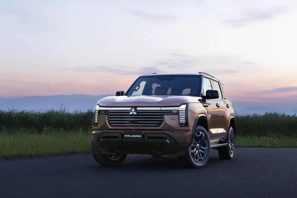 SUV Mitsubishi Pajero avec design élégant au crépuscule, paysage naturel en arrière-plan.