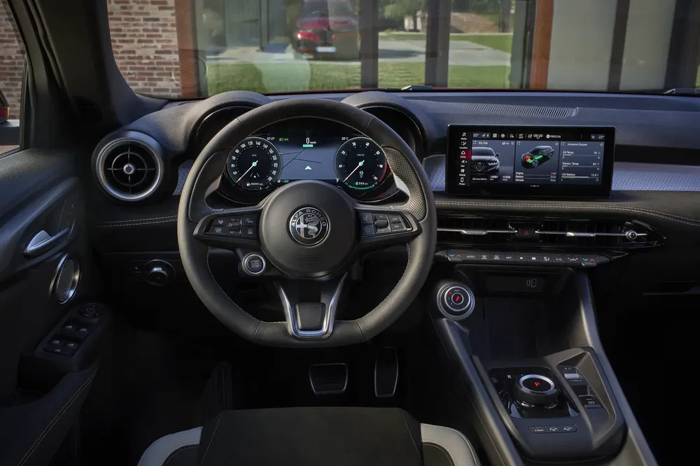 Moderne interieur van een Alfa Romeo met digitaal dashboard en centraal touchscreen.