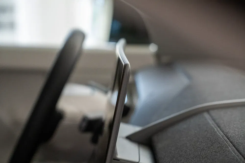 Écran tactile et volant d'une voiture moderne, mettant en avant le design épuré.