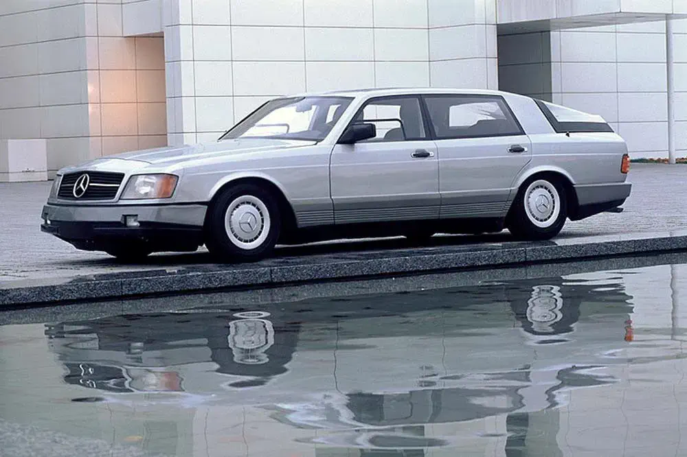 Zilverkleurige Mercedes-Benz stationwagen, jaren '80, weerspiegeld in het water, klassieke vormgeving.