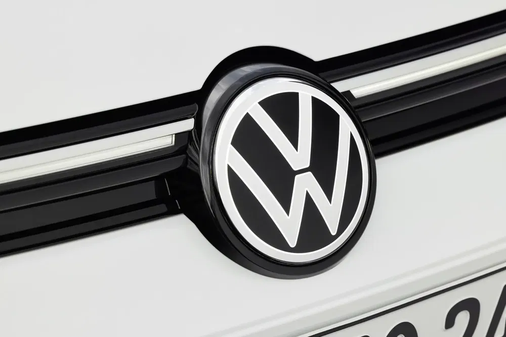 Volkswagen-logo op witte motorkap, close-up met strak, modern ontwerp.