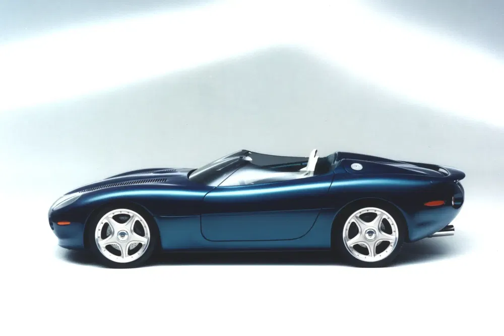 Jaguar XJ220 bleu, deux places, design élégant, vue latérale, jantes chromées.