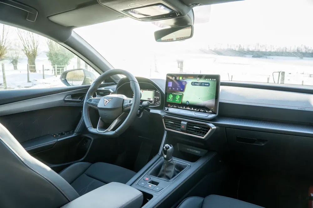 Moderne en stijlvolle interieurruimte van een Cupra met touchscreen en sportstuur.