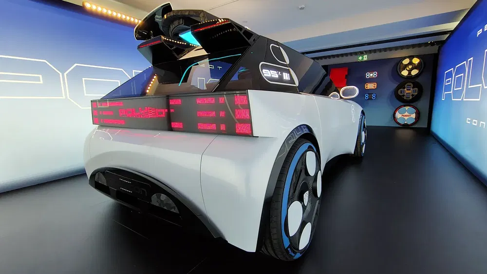 Concept-car futuriste avec éclairage LED rouge et roues ultra-modernes en salle d'exposition.