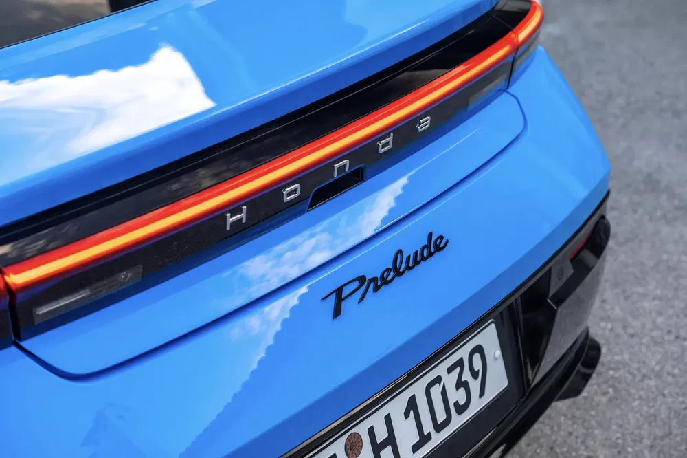 Achterkant van blauwe Honda Prelude met opvallend logo en zichtbare nummerplaat.