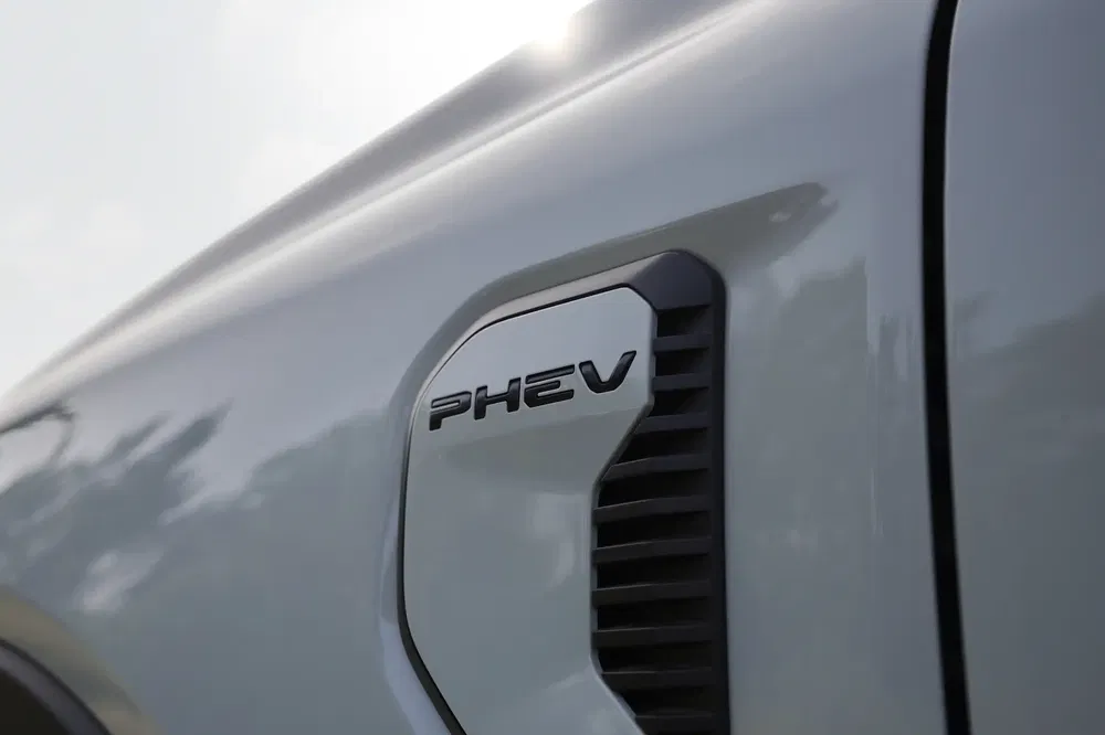 PHEV-embleem op zijpaneel van grijze hybride auto, elegant en modern ontwerp.