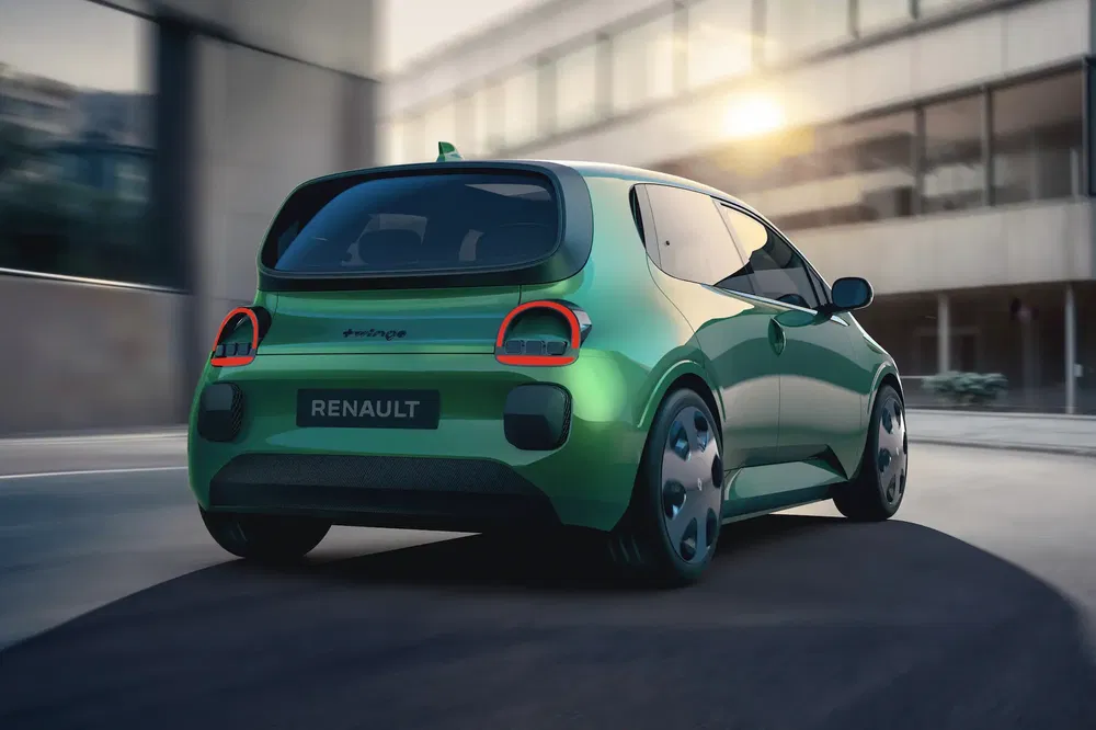 Renault Twingo verte moderne, vue arrière dans un environnement urbain au coucher du soleil.