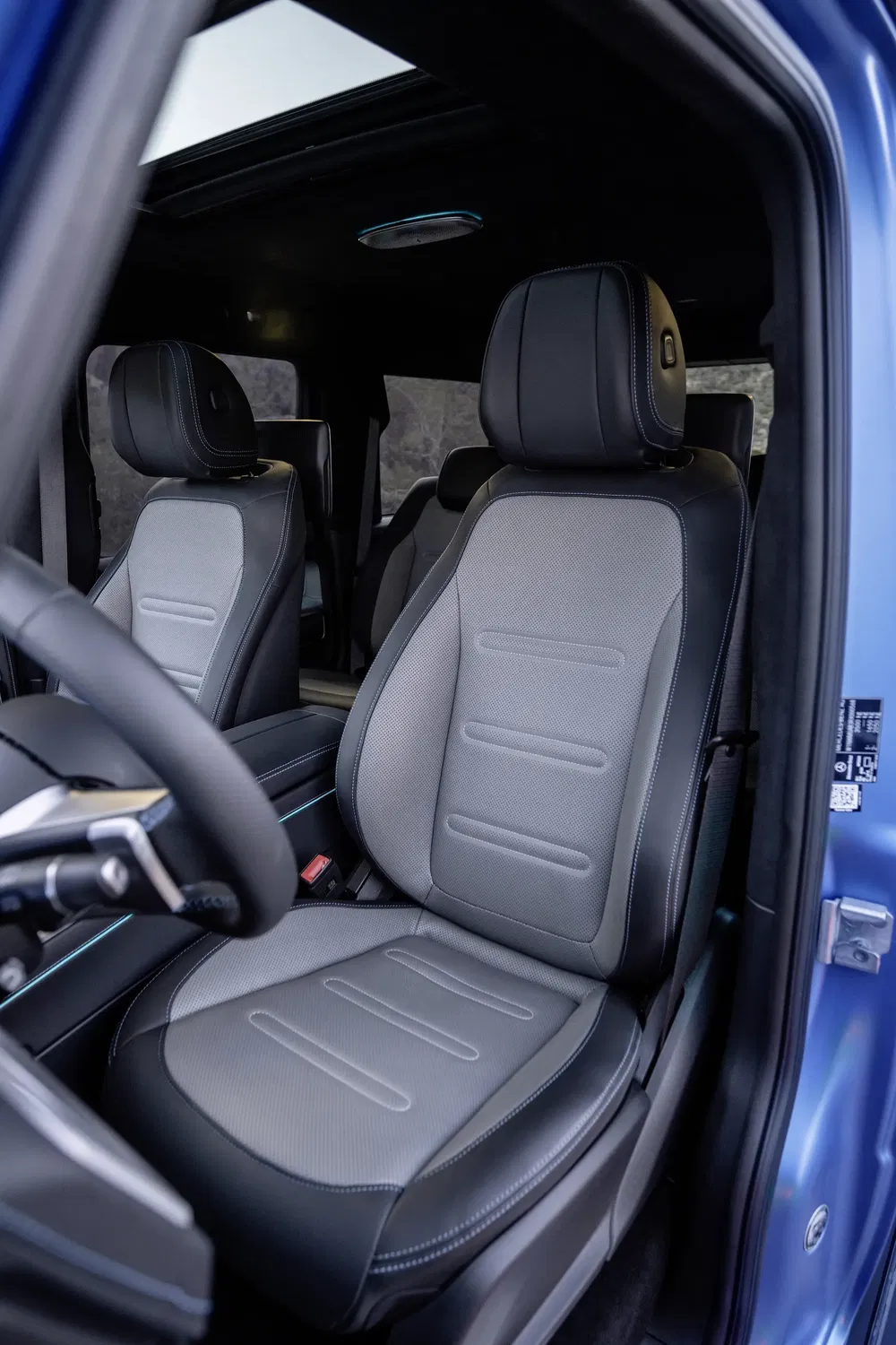 Intérieur d'une Ford électrique avec sièges en cuir gris et tableau de bord moderne.