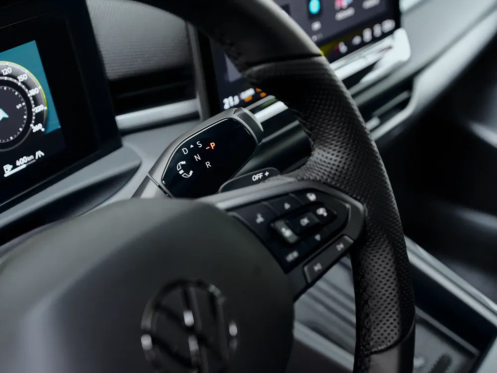 Moderne Volkswagen autointerieur, zichtbaar stuurwiel en digitale versnellingspook.