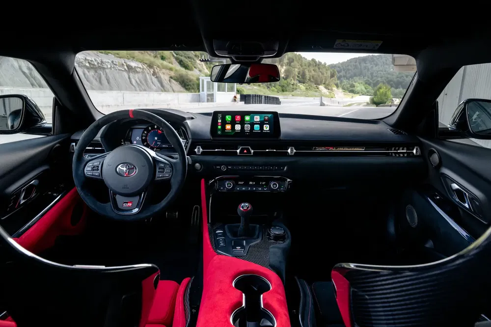 Interieur van een Toyota Supra, high-tech dashboard met modern centraal scherm.