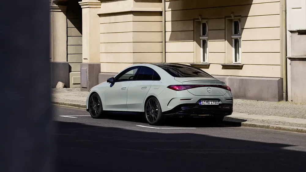 Mercedes-Benz CLA garé en ville, design moderne et élégant, jantes noires distinctives.