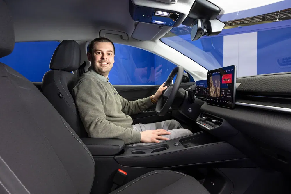 Homme au volant d'une voiture moderne avec écran tactile, intérieur Ford blue.