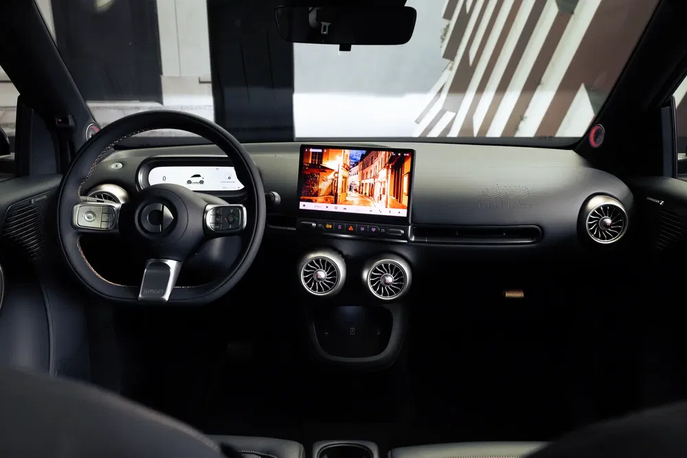 Interieur van Smart EQ auto met geavanceerd stuur en centraal scherm.