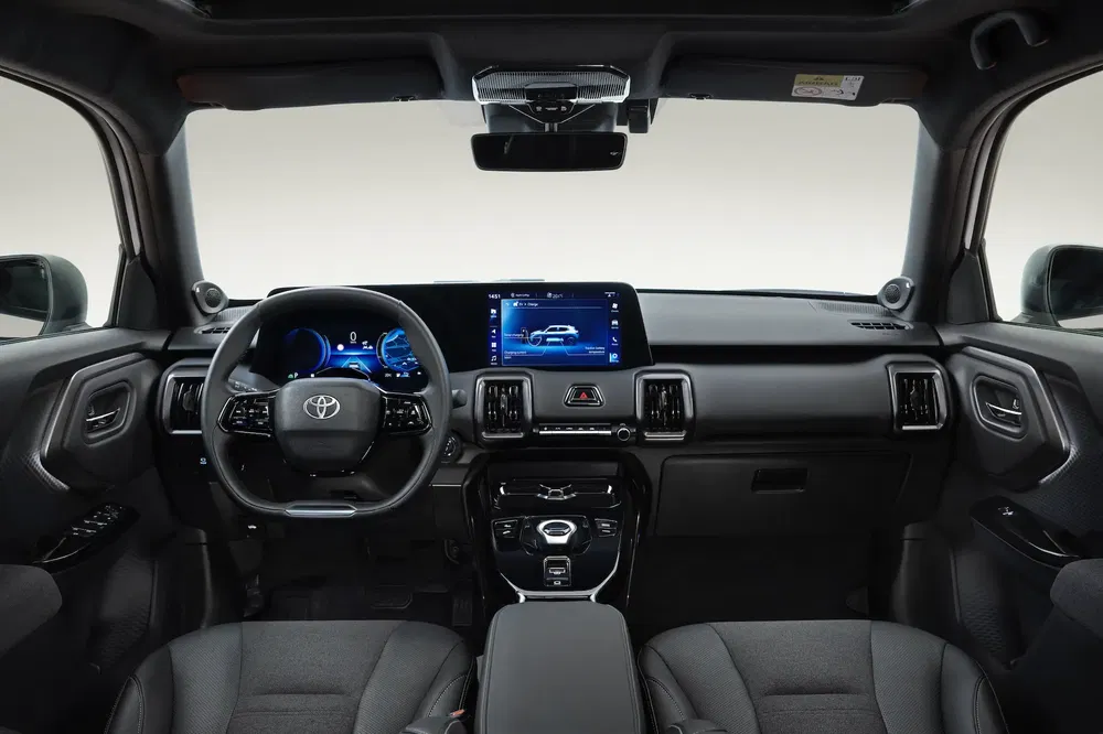 Moderne interieur van de Toyota Land Cruiser met digitaal dashboard en centraal touchscreen.