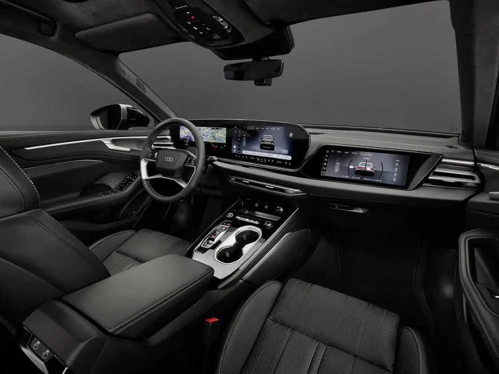 Moderne Audi-interieur met digitaal dashboard en zwarte lederen stoelen.