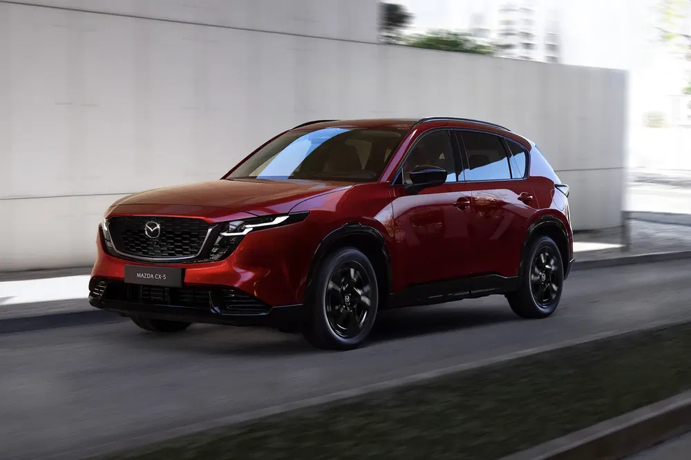 Rode Mazda CX-5 rijdend door stedelijk tunnel, elegante en moderne uitstraling.