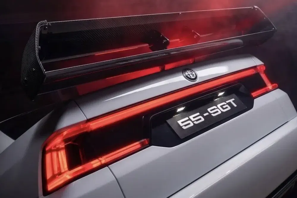 Détail d'une Alfa Romeo avec un aileron en fibre de carbone et des feux arrière distinctifs.