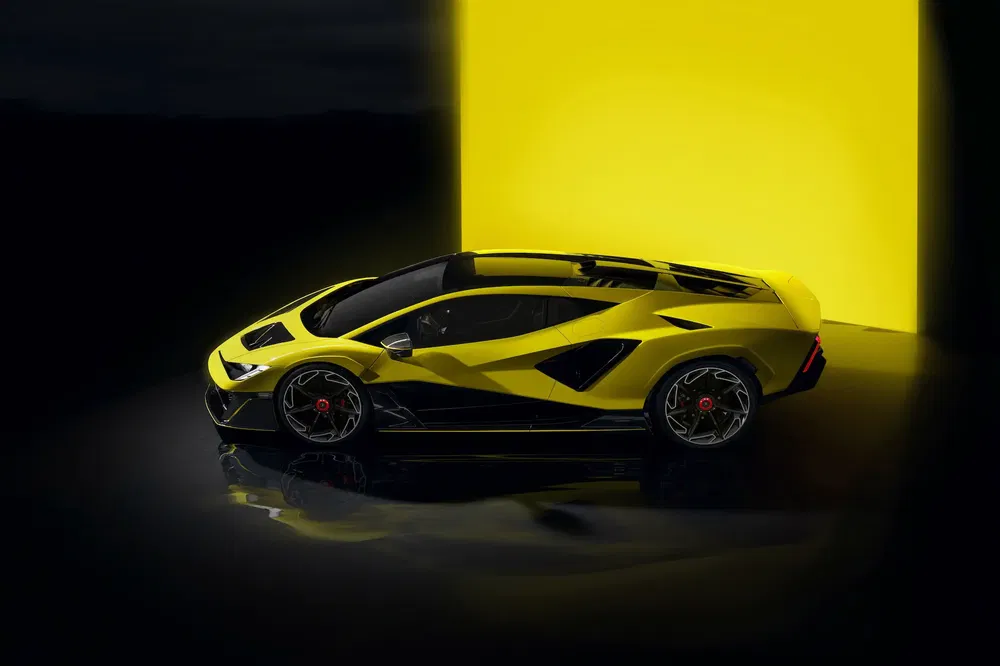 {"fr":"Supercar Lamborghini jaune vif avec des lignes noires, éclairée par une lumière contrastée.","nl":"Felgele Lamborghini supercar met zwarte lijnen, verlicht door contrasterend licht."}