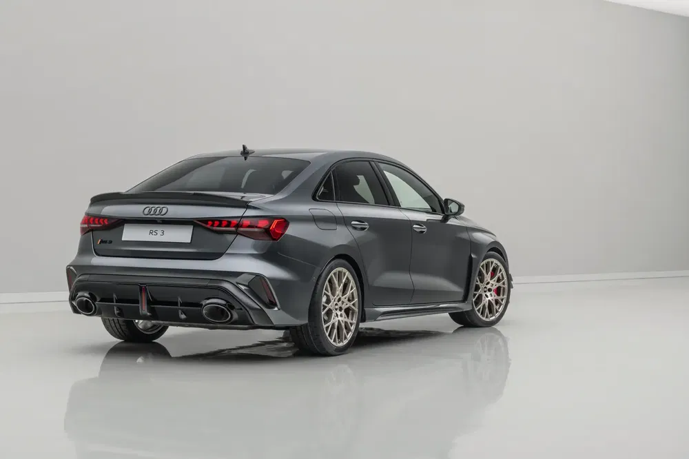 Audi RS3 gris foncé, vue arrière, sur fond neutre, roues sports en alliage.