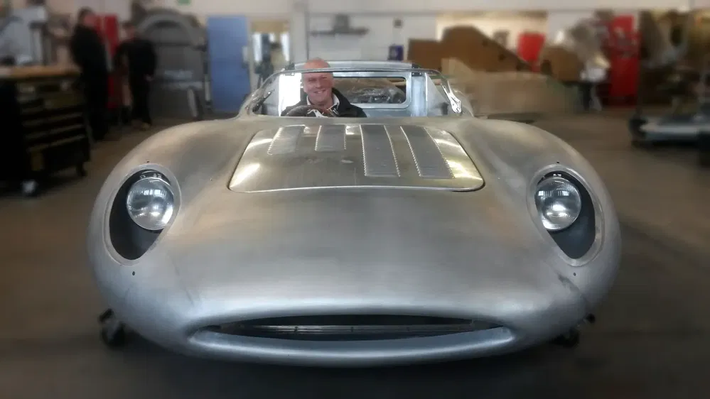 Prototype de voiture Jaguar en métal nu dans un atelier automobile.