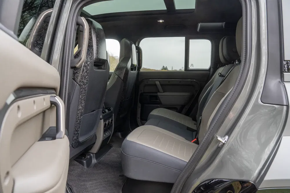 Intérieur spacieux d'un véhicule tout-terrain Land Rover Defender, avec sièges arrière haut de gamme.