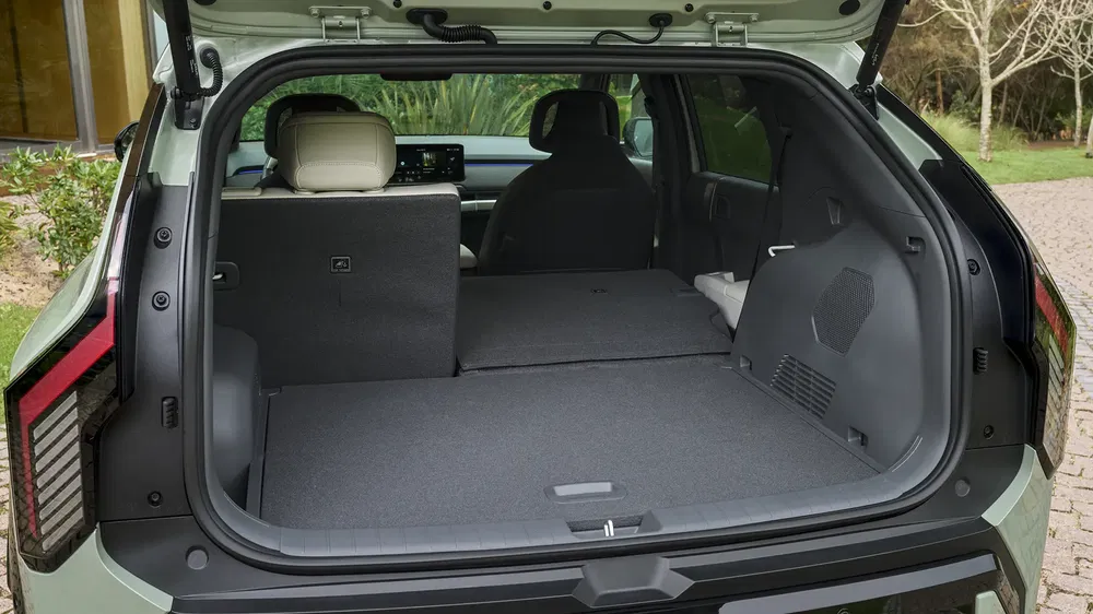 Ruime kofferbak van een Kia EV9 SUV met neergeklapte achterstoelen, toont modern interieur.
