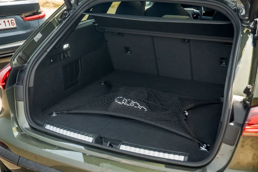 Ruime kofferbak van een elektrische Audi met opbergnet en zichtbaar Audi-logo.