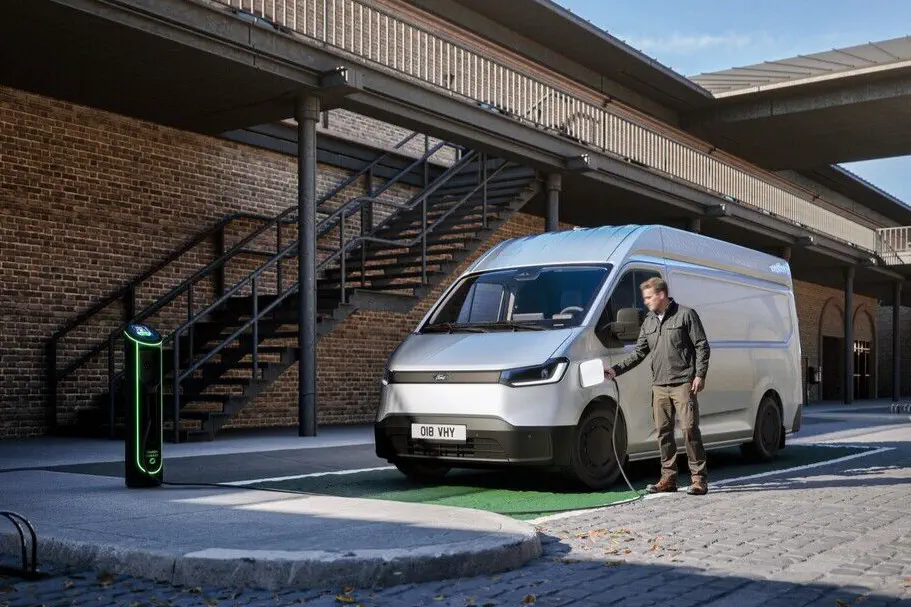 Man laadt elektrische bestelwagen op bij moderne laadpaal in stedelijke omgeving.