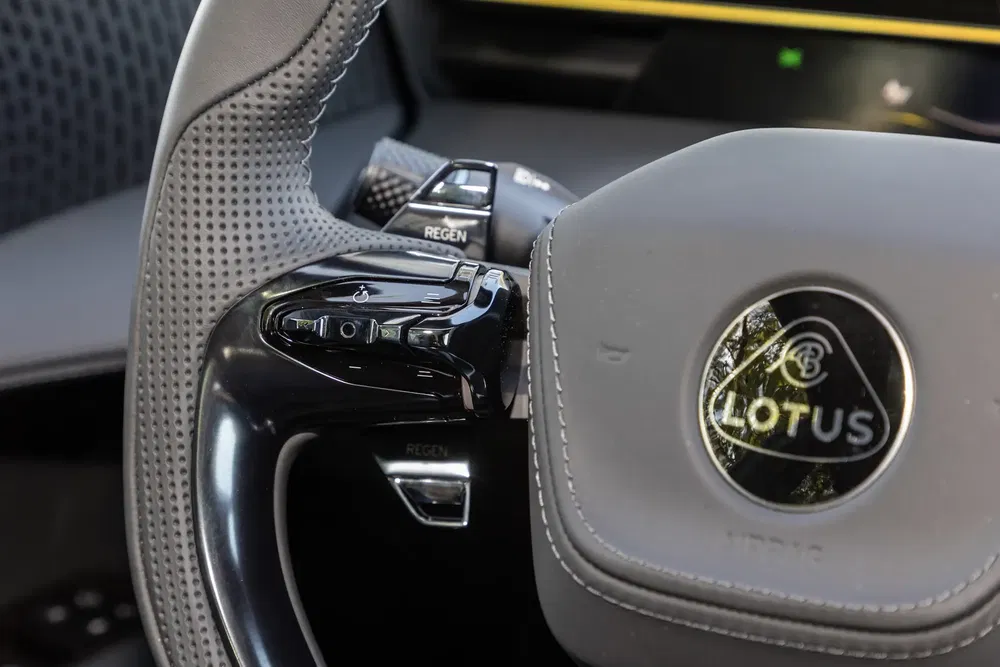 Volant de voiture Lotus moderne avec commandes intégrées et logo distinctif.