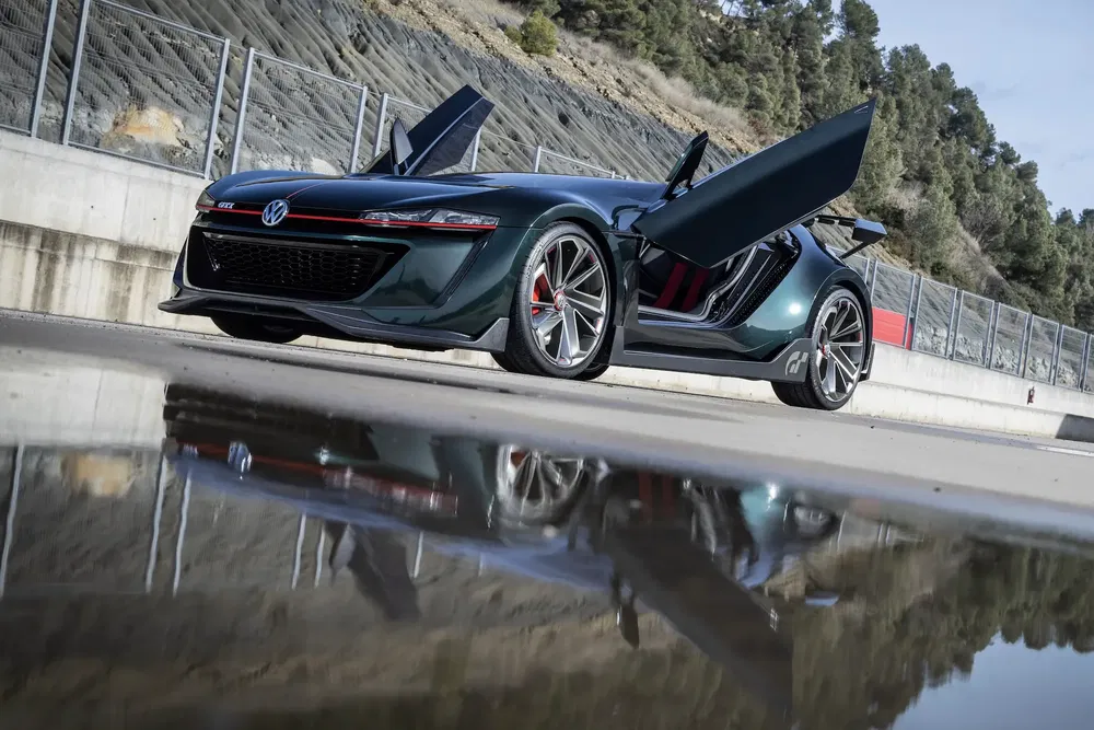 {"fr":"Volkswagen GTI Concept avec portes papillon, reflets dans une flaque sur piste.","nl":"Volkswagen GTI Concept met vleugeldeuren, weerspiegeld in een plas op het circuit."}