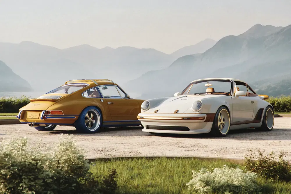 Deux Porsche classiques stationnées avec vue sur des montagnes et un lac majestueux.