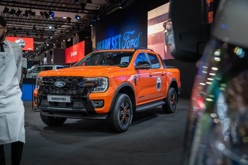 {"fr":"Nouveau Ford Ranger PHEV orange exposé au salon automobile, éclairage moderne en arrière-plan.","nl":"Nieuwe oranje Ford Ranger PHEV tentoongesteld op autoshow, met moderne verlichting op de achtergrond."}