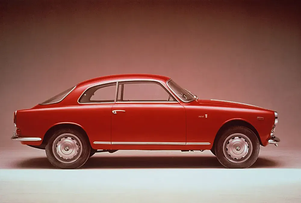 Voiture classique rouge Alfa Romeo Giulietta Sprint profilée sur fond neutre.